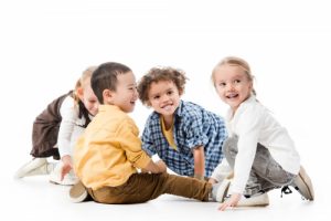 adorable smiling multicultural kids playing on white