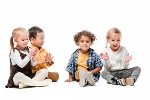 happy adorable multicultural kids playing on white