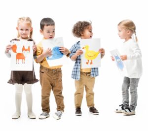 multicultural kids holding paintings, isolated on white